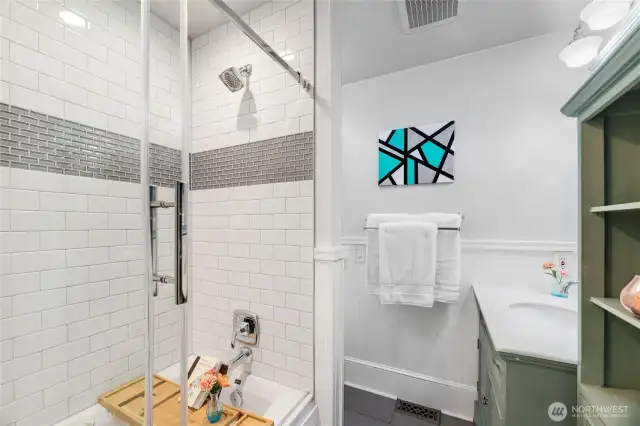 Updated Bathroom for 2nd and 3rd Bedroom features a jetted bathtub and glass shower door