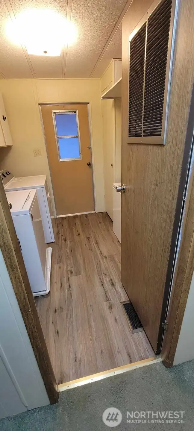 Utility room with new floor and access to covered deck.