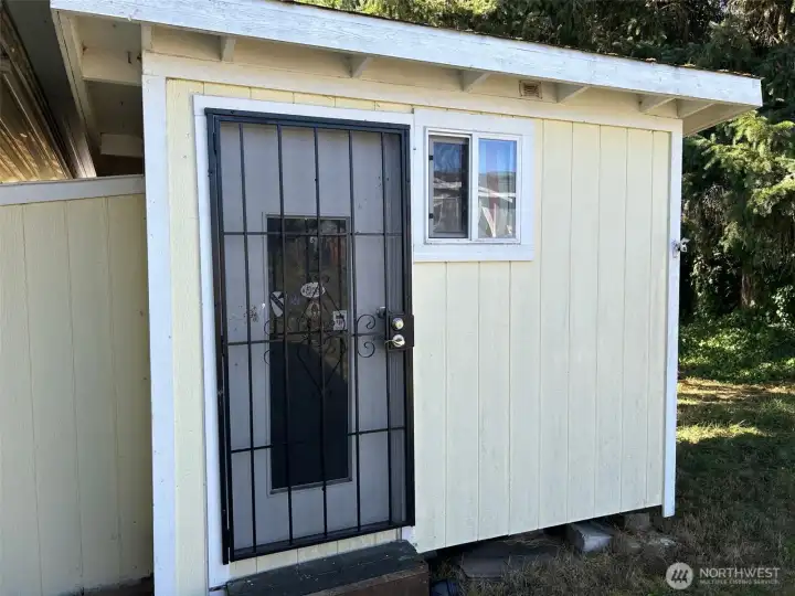 Secure storage shed behind carport