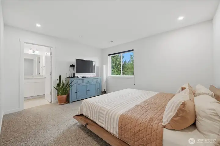 Lovely primary suite with huge window to the trees behind the home