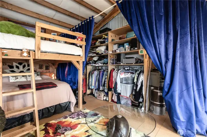 Solid wood bunk bed and storage nook with rustic hand-hewn curtain rods and heavy theater-style drapery for a unique, cozy aesthetic.