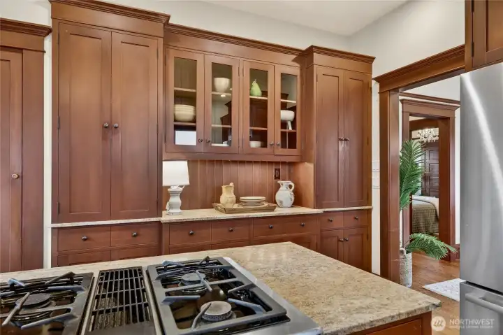 Very useful coffee bar with glass fronted cabinets and a tall cabinet for brooms and vacuum to the left.