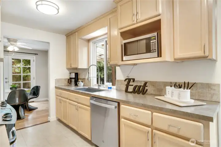 Functional kitchen with stainless steel appliances, ideally situated between the casual sitting area and formal dining room