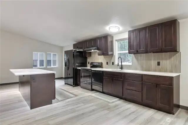 Kitchen with vaulted ceilings and quartz countertops.