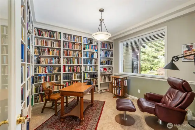 Warm and cozy, the office/library space enjoys walls of built-ins and a place to relax, rain or shine.