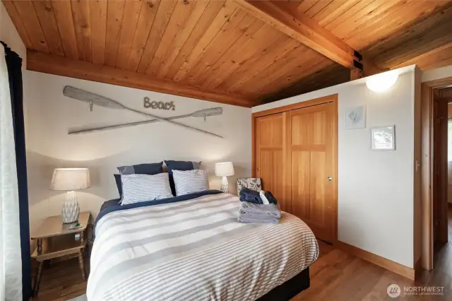 one of the two bedrooms on the main floor, solid fir doors, wood beams and gorgeous wood ceilings