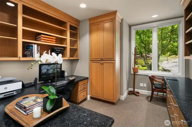 Main floor office with 2 work stations and custom built in office furniture and cabinets.