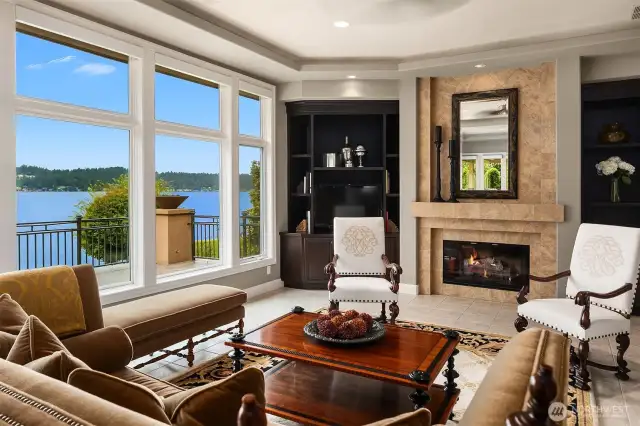 The open concept living room with loads of furniture grade cabinetry, anchoring fireplace and stellar lake views.
