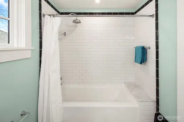 Gorgeous tiled shower, large tub and a vintage feel.