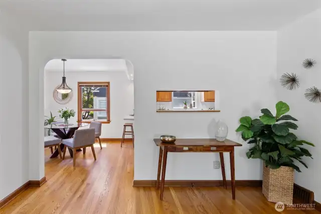 The arched entrance to the dining room reflects the home's 1940's style. Owners added a small "window" to the kitchen to open up the view.