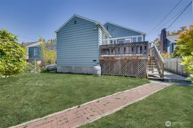 View of back of the house and deck, taken from the fence line.