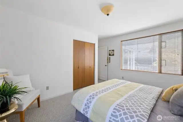 View looking toward double closet, entrance, and window overlooking deck.