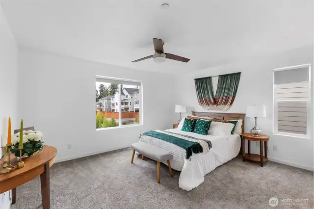 Primary suite features en suite bath, walk-in closet and handy ceiling fan.