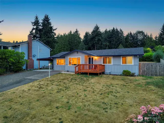 Warm evening light welcomes you to this beautifully remodeled Poulsbo home. The inviting front deck is perfect for enjoying quiet sunsets, while the spacious front yard offers endless possibilities for gardening or play.