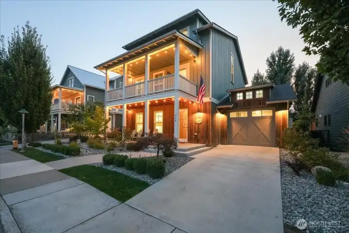 Exterior twilight view of front of home with covered porch and 1 car garage.