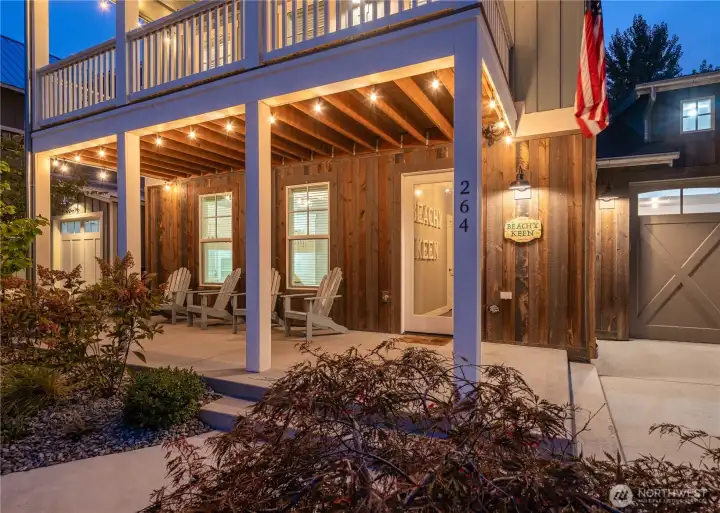 Exterior twilight view of front door with classic covered porch and 1-car garage.