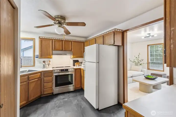 Spacious kitchen with ample cabinetry, updated stainless-steel range, and a convenient pass-through layout that opens into the cozy living area.
