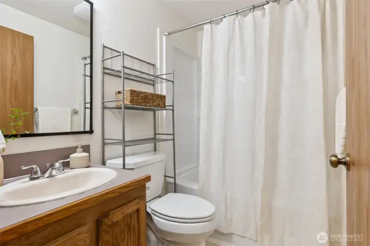Clean and bright full bathroom with updated fixtures, ample storage, and a fresh neutral palette.