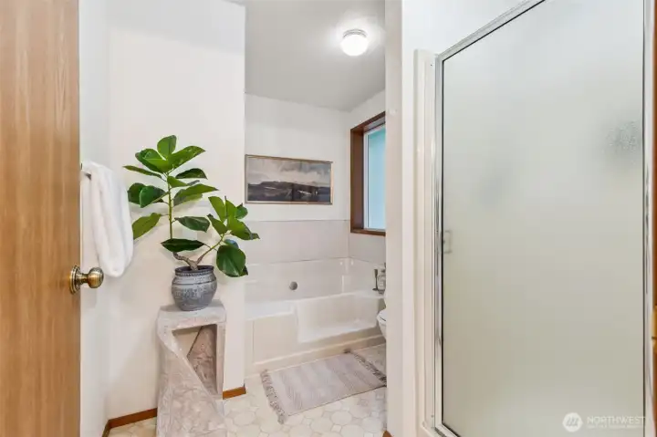 Bright and inviting ensuite bath featuring a soaking tub, separate shower, and serene natural light—your own private retreat.