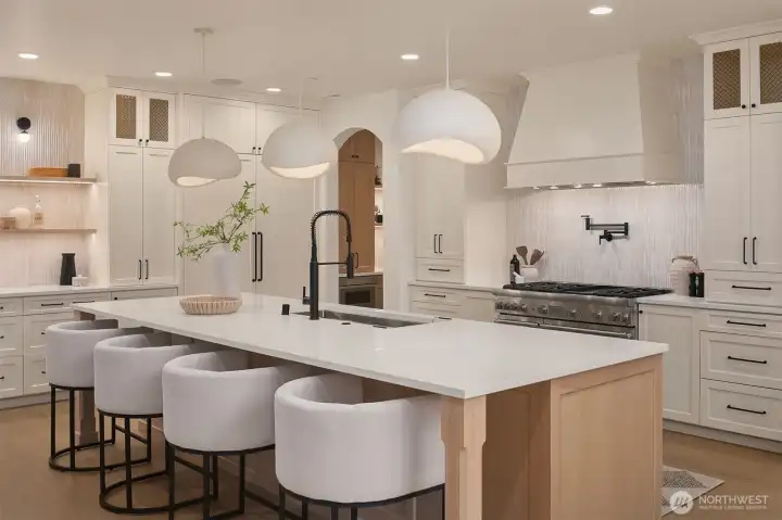 Chef’s kitchen featuring Thermador appliances, expansive island with seating, custom cabinetry, walk-in pantry, and designer pendant lighting, thoughtfully designed for both everyday living and entertaining.