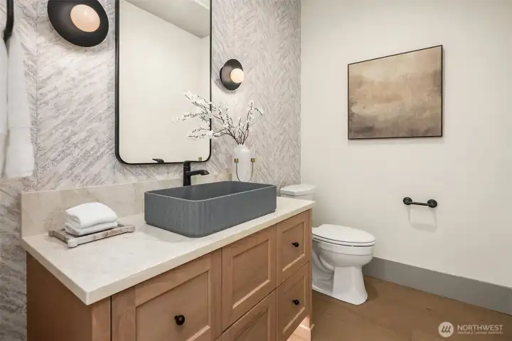 Designer powder room with custom vanity, statement lighting, and motion-sensor toe-kick lighting for added function and ambiance.