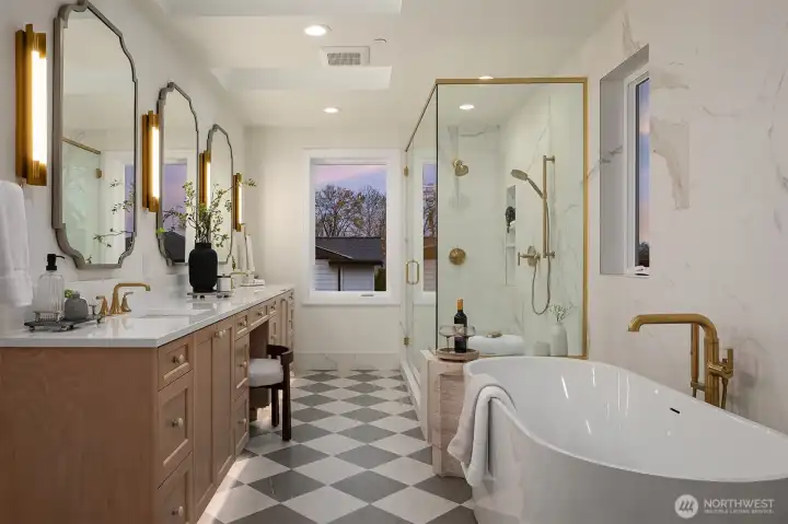 Spa-inspired primary bathroom featuring radiant heated floors, motion-sensor toe-kick lighting, freestanding soaking tub, glass-enclosed shower, dual vanity, and designer finishes.