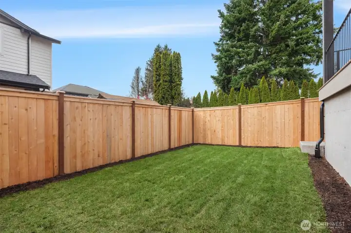 Private, fully fenced backyard with fresh landscaping.