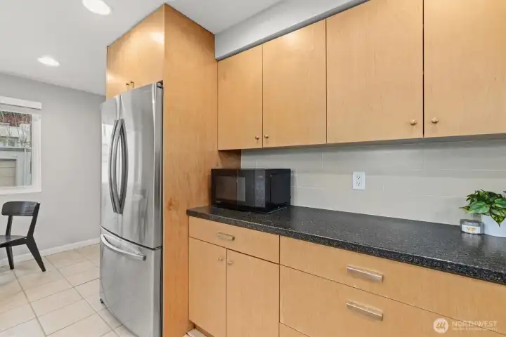 Modern hardware has been added; the stainless steel fridge is ready for your groceries.