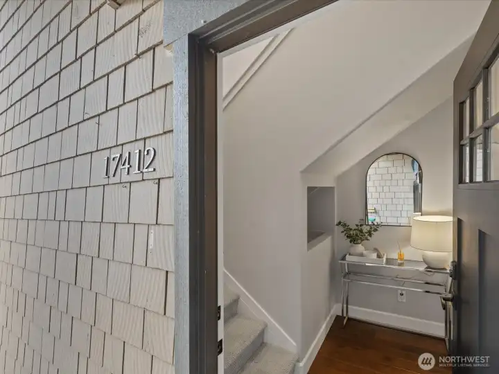 Entry to unit with vaulted ceiling staircase, hardwood flooring, and interior landing area