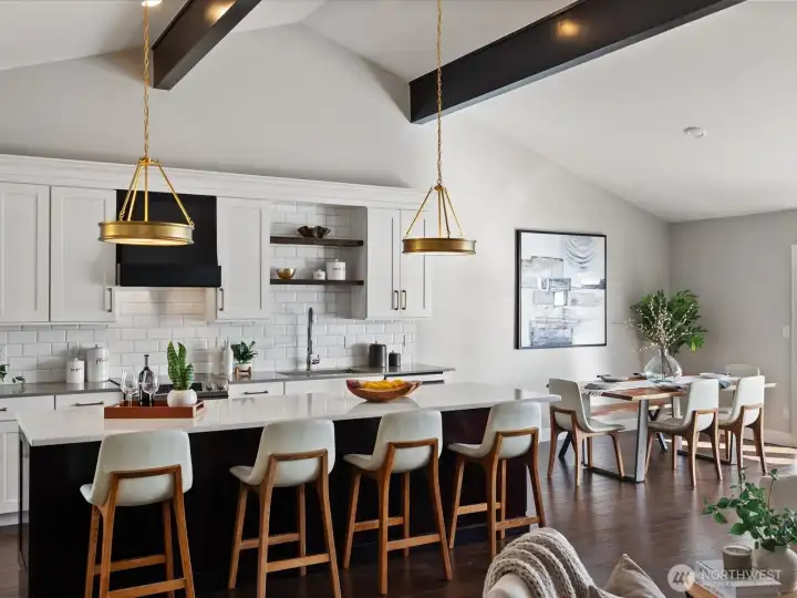Kitchen with quartz countertops, island seating, tile backsplash, and adjacent dining area under vaulted ceilings