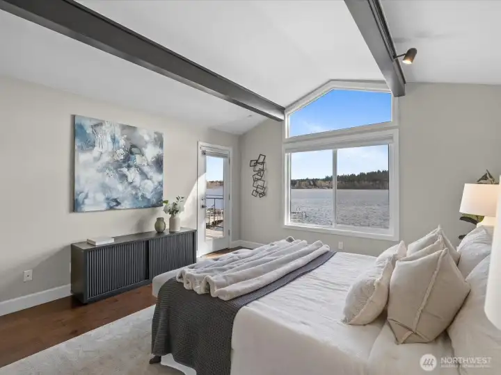 Primary bedroom with vaulted ceilings, large windows, and direct Lake Sammamish views with access to exterior deck