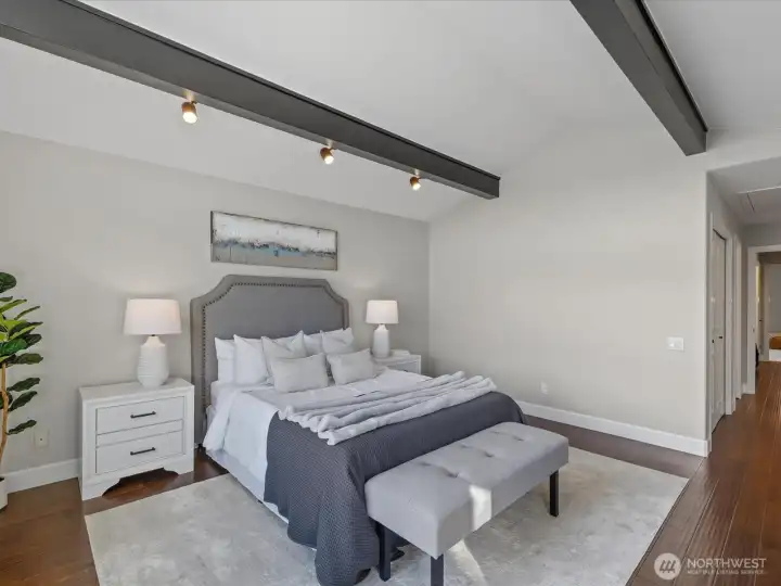 Bedroom with vaulted ceilings, hardwood flooring, and adjacent hallway access