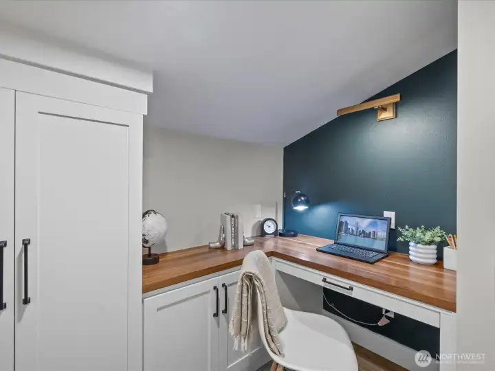 Built-in office nook with desk, cabinetry, and workspace