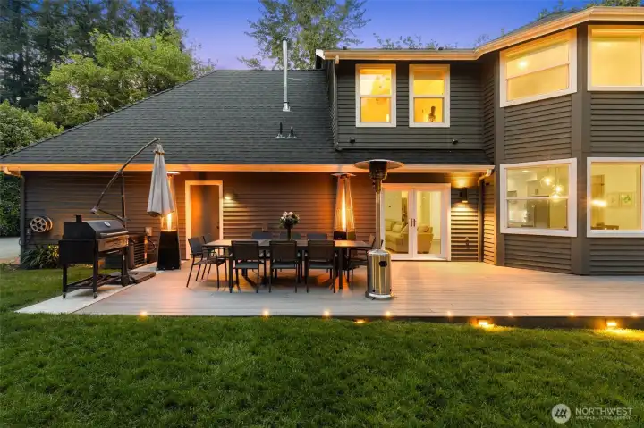 Newly expanded deck with built-in seating overlooking the creek and trees