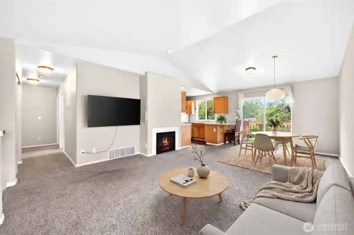 Virtually staged large great room off main level with vaulted ceilings gas fire place and light bright colors