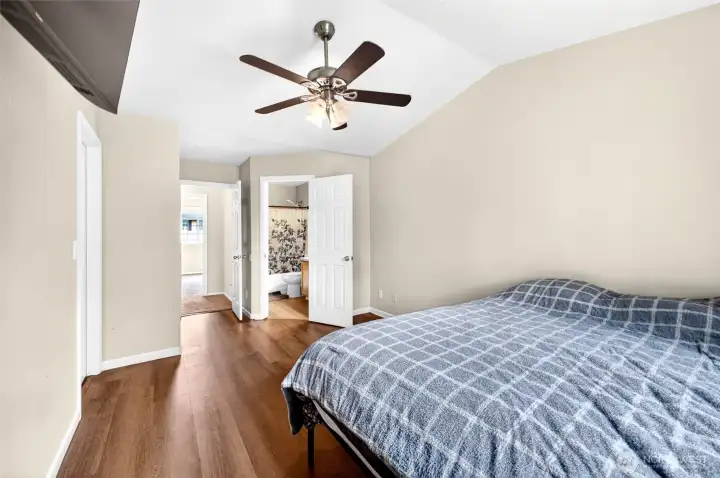 Large primary bedroom on main level with LVP flooring ceiling fans and private bathroom
