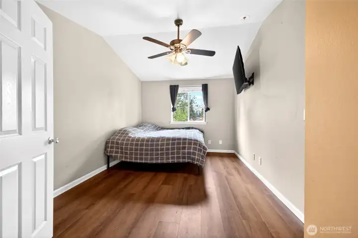 Second view of primary bedroom with vaulted ceilings