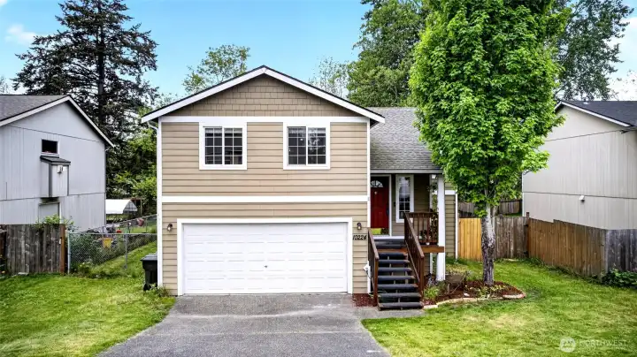 Front view with updated landscaping newer deck and large 2 car garage