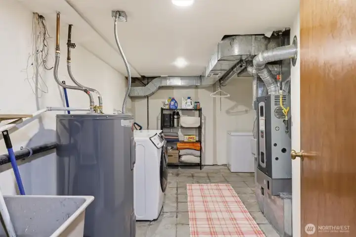 Functional basement laundry room with extra room for storage and everyday convenience.