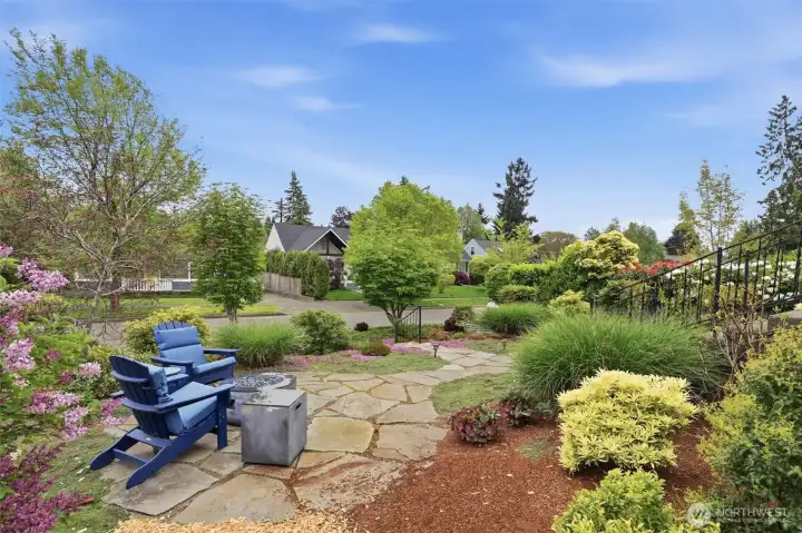 Beautifully landscaped garden area with fire pit creates a warm and inviting outdoor retreat.