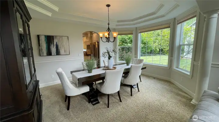 FORMAL DINING ROOM surrounded by BAY WINDOWS and DOUBLE COFFERED CEILING.