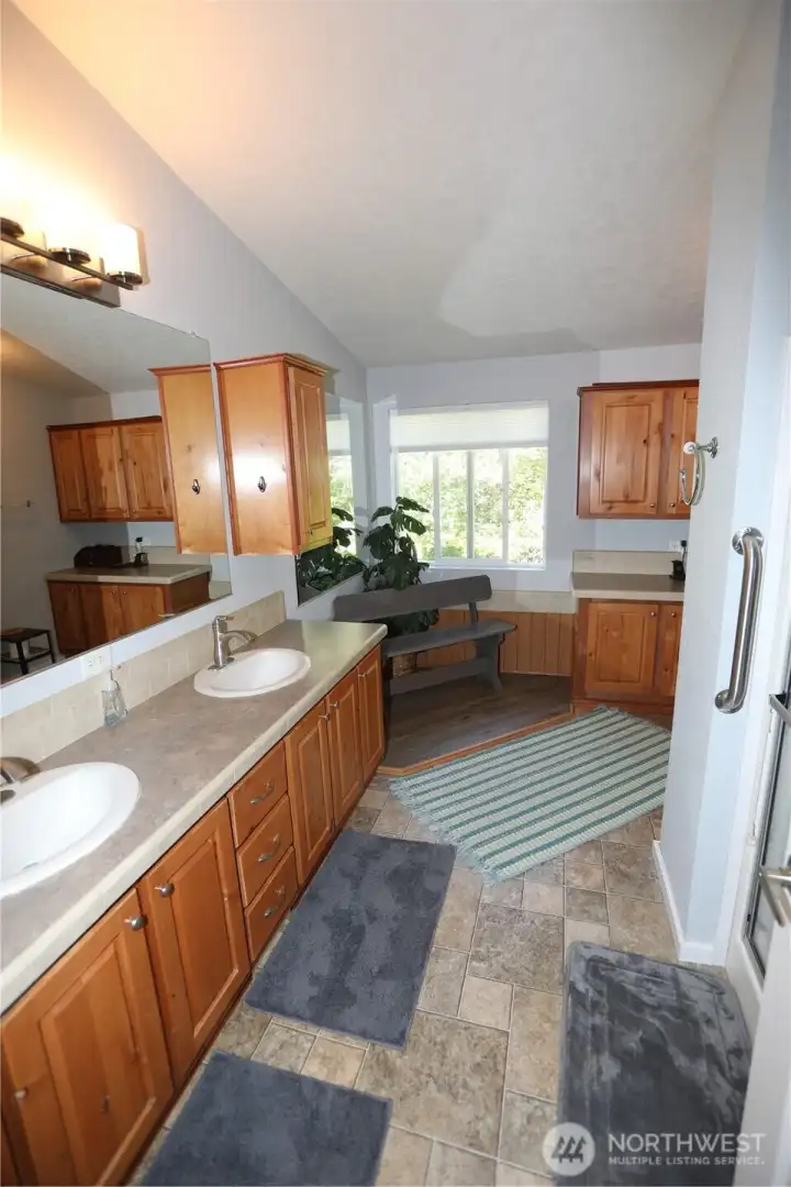 Huge double vanity primary bath with walk in shower and sitting area.
