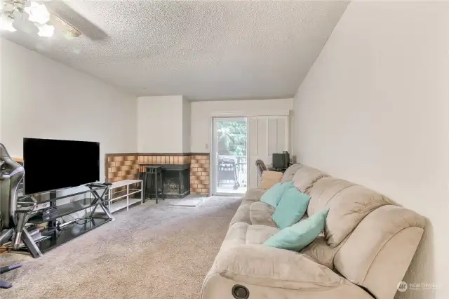 Spacious living room with a fireplace that invites relaxation. A slider opens to the balcony.