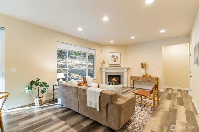 This open-concept living space features soaring ceilings, large windows, and a cozy gas fireplace—perfect for relaxing or entertaining.