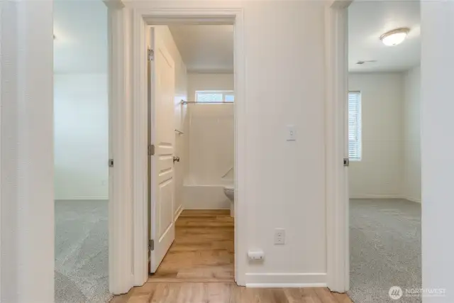 hallway facing full bath and secondary bedrooms