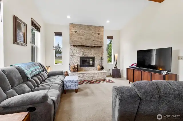 Floor to ceiling stone fireplace captivates in this living room