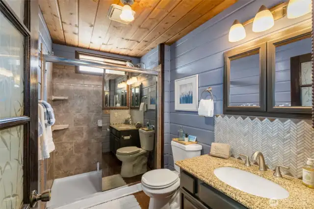 The main floor bath has a walk-in shower and marble backsplash.