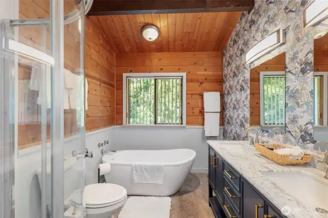 The recently remodeled primary bath features a vessel tub and new vanity with double sinks and a quartz counter top.