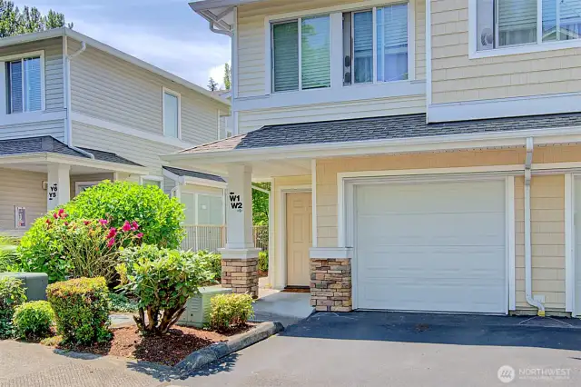 Front view of unit's garage with front door access on the left.