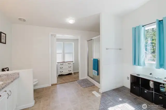 Huge primary bathroom! The area to the right is plumbed for a bathtub if you wish! Barn door is open to see the walk-in closet